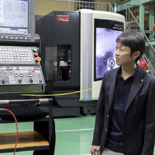 MUQUアンバサダーに先立ち、自身のモデルアイアンの製造現場に訪れ、迫田副社長から説明を受ける。