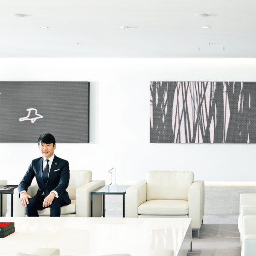 オピーが飾られた応接室に座る熊谷氏