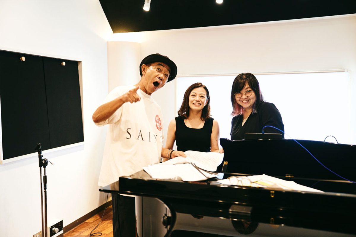 リハーサル中の木梨さんと、指揮者の三ツ橋さん、音楽監督・ピアノ・編曲を担当する直江さん。