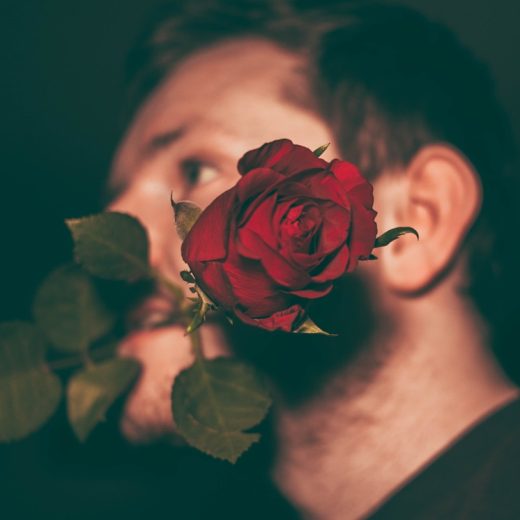 バラをくわえた男性