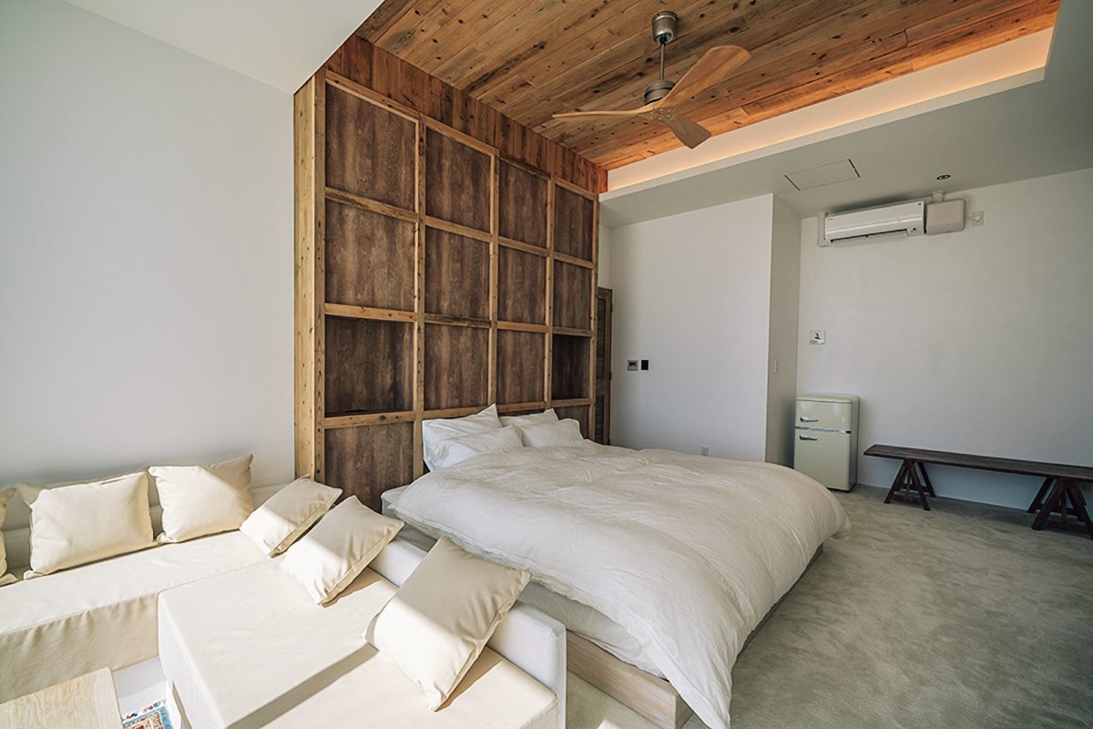 ヘッドボードから天井まで古木風の木材を用い、落ち着いた雰囲気のマスターベッドルーム。