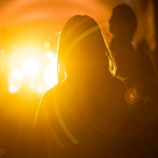 光が当たる女性の後ろ姿