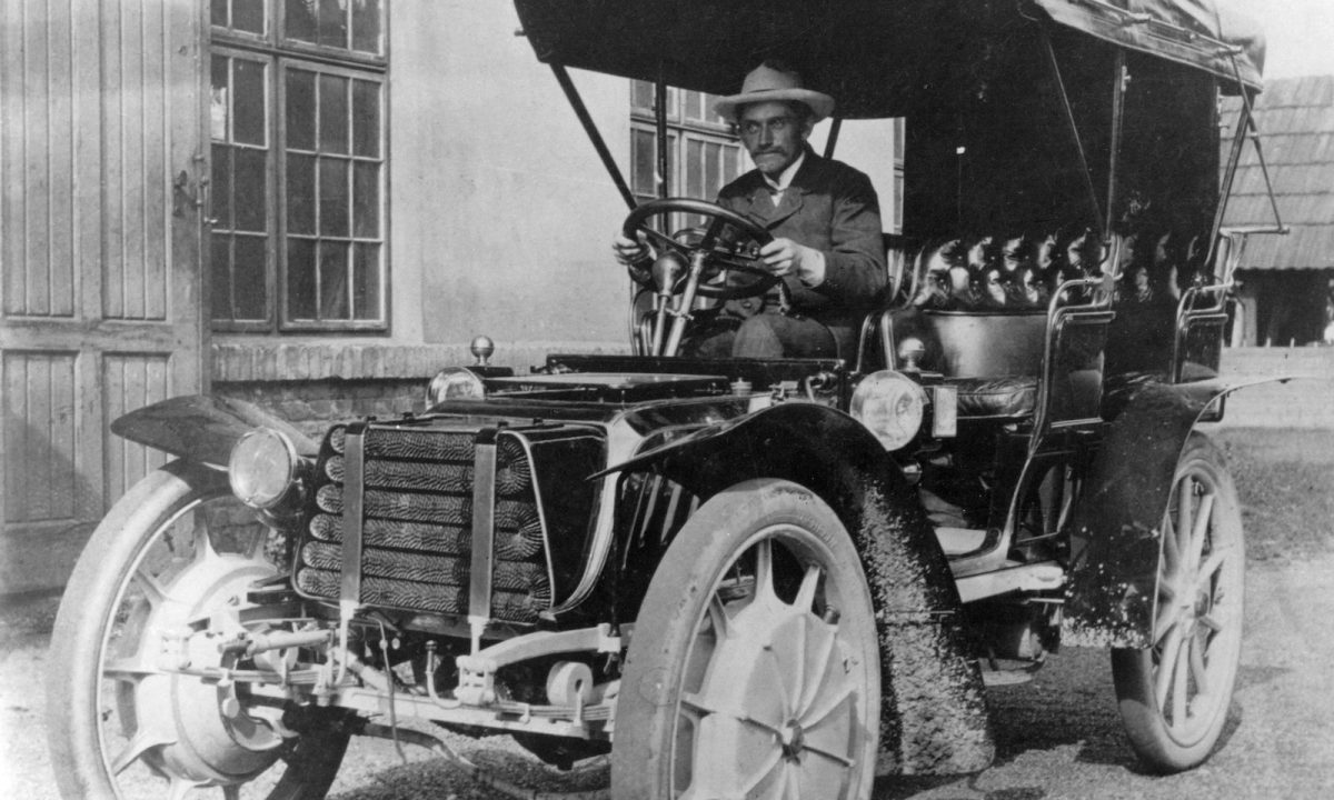 1900年、帝室馬車工房ローナー社で現代のハイブリッド車の始祖ともいえる試作車をテストするフェルディナント・ポルシェ博士。