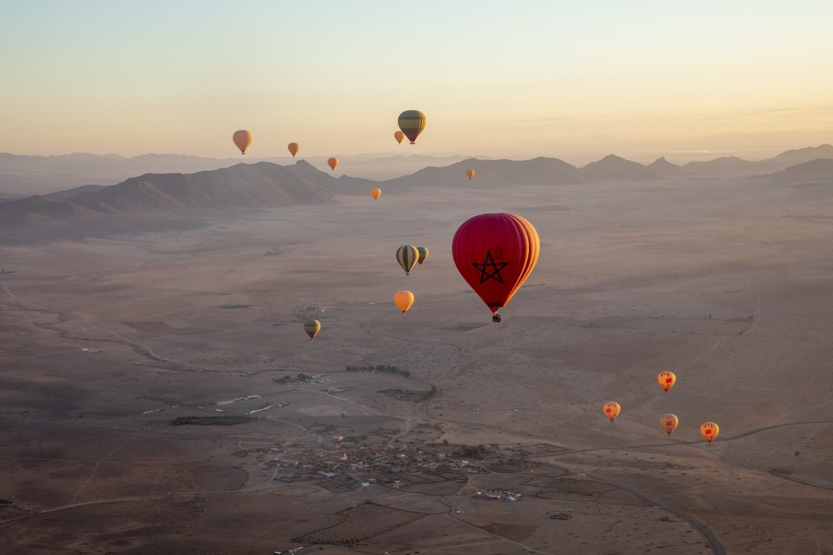 夜明け前、マラケシュ郊外の荒野から複数の気球が浮上する。