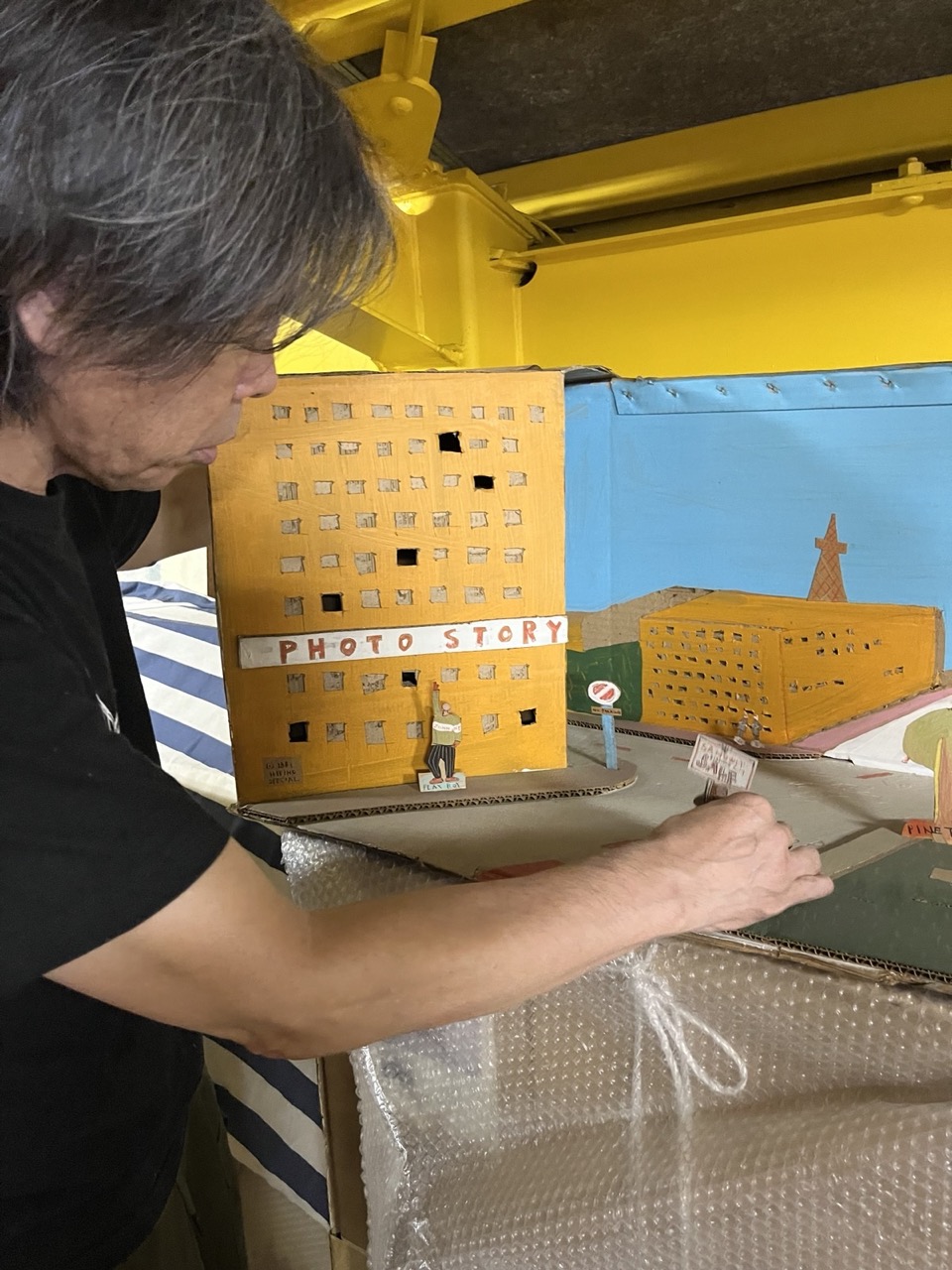 岐阜の実家近くの倉庫で作品を選んでいる日比野氏。