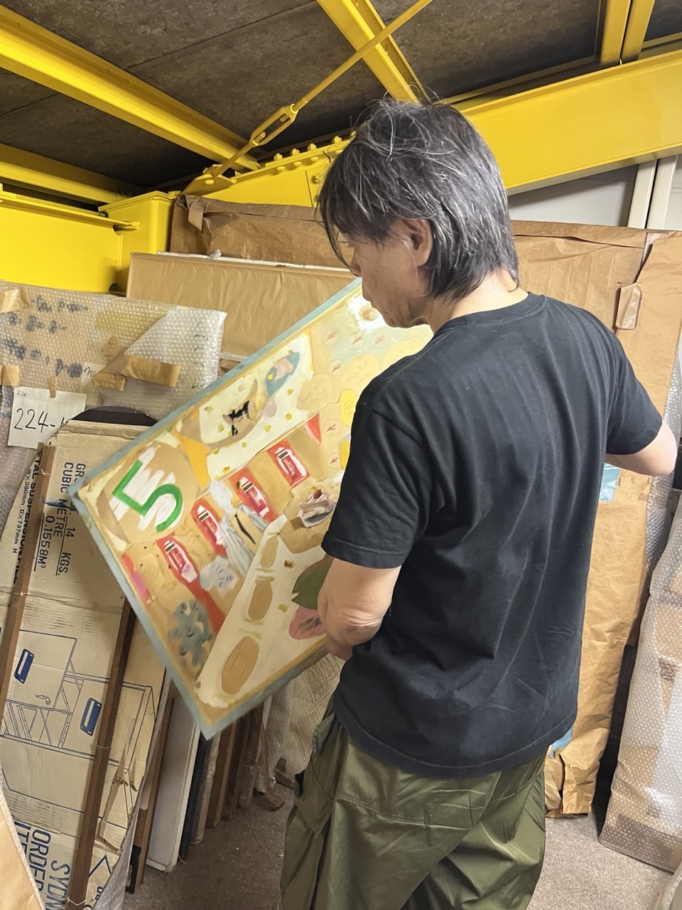 岐阜の実家近くの倉庫で作品を選んでいる日比野氏。